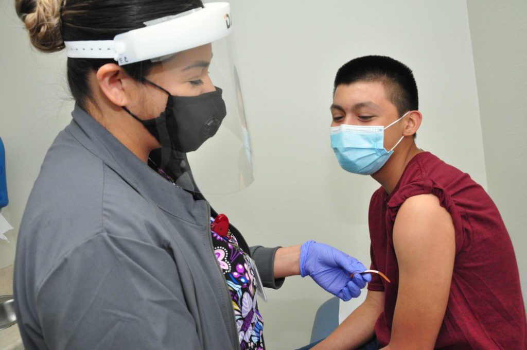LaSalle Medical Associates Nurse Elisabeth gives Eduaido Torres 13 a vaccination.